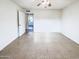 Bright bedroom with neutral tile, ceiling fan, and open door leading to the hallway at 17405 N 19Th Dr, Phoenix, AZ 85023