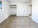 Empty bedroom featuring tile flooring, closet, and a door leading to other parts of the home at 17405 N 19Th Dr, Phoenix, AZ 85023