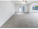 Comfortable living room with neutral carpet, ceiling fan, and view of backyard at 17405 N 19Th Dr, Phoenix, AZ 85023