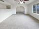 Bright living room with neutral carpet, ceiling fan, and view of a spacious archway at 17405 N 19Th Dr, Phoenix, AZ 85023