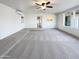 Bright living room features a ceiling fan, carpeted floors, painted brick walls, and light-filled windows at 17405 N 19Th Dr, Phoenix, AZ 85023