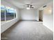 Spacious, carpeted living room with a ceiling fan and a large window offering ample natural light and backyard views at 17405 N 19Th Dr, Phoenix, AZ 85023