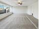 Sunlit living room featuring neutral carpet, brick accent wall, and ceiling fan at 17405 N 19Th Dr, Phoenix, AZ 85023