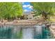 Landscaped backyard with waterfront views and a tranquil waterfall feature, perfect for outdoor relaxation at 175 N Brookside St, Chandler, AZ 85225