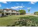 Large backyard showcases mature trees, ample lawn space, and covered patio of this home at 175 N Brookside St, Chandler, AZ 85225