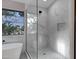 Modern bathroom features a soaking tub and glass-enclosed shower with marble walls and pebble flooring at 175 N Brookside St, Chandler, AZ 85225