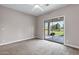 Spacious bedroom with plush carpeting, ceiling fan, and sliding glass doors to the backyard at 175 N Brookside St, Chandler, AZ 85225