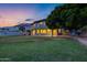 Spacious two-story home with a large grassy backyard and mature trees at dusk at 175 N Brookside St, Chandler, AZ 85225