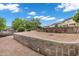 Well-maintained yard with beautiful lake views, mature landscaping, and stone retaining wall at 175 N Brookside St, Chandler, AZ 85225