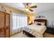 Bedroom featuring a ceiling fan, large window, and a cozy bed with decorative pillows at 17500 N 85Th Dr, Peoria, AZ 85382