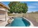 Backyard features a beautiful pool with stone accents, complemented by lush greenery, perfect for a relaxing oasis at 17500 N 85Th Dr, Peoria, AZ 85382