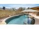 Inviting backyard pool with rock accents and shaded seating area, perfect for relaxation and outdoor entertaining at 17500 N 85Th Dr, Peoria, AZ 85382