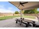 Back patio, complete with a ceiling fan, picnic table, large backyard, and surrounding privacy fence at 20017 N 65Th Dr, Glendale, AZ 85308