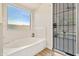 Bathroom features white tub, wood tile flooring, and a window with a view of the outdoors at 20017 N 65Th Dr, Glendale, AZ 85308