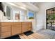Bathroom boasts dual sinks, wooden cabinets, and direct access to the outdoor living space at 20017 N 65Th Dr, Glendale, AZ 85308