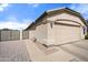 Attached two-car garage with a paved walkway leading to a gated side yard at 20017 N 65Th Dr, Glendale, AZ 85308