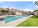 Backyard with a pool, covered patio, artificial turf, and a privacy fence providing a relaxing outdoor space at 20017 N 65Th Dr, Glendale, AZ 85308