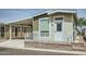 Charming home exterior featuring a covered parking area and a welcoming front porch with white railing at 2206 S Ellsworth Rd # 129B, Mesa, AZ 85201