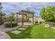 Well-kept backyard with lush green grass, a modern pergola, and neat landscaping at 2949 E Athena Ave, Gilbert, AZ 85297