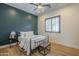 Relaxing bedroom with a dark teal accent wall, natural light, a ceiling fan, and comfortable furniture at 2949 E Athena Ave, Gilbert, AZ 85297