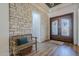 Beautiful foyer with a stone accent wall, wooden bench, and a decorative wood and glass front door at 2949 E Athena Ave, Gilbert, AZ 85297