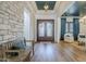 Inviting foyer featuring a decorative wood and glass front door, stone accent wall, and wood-look flooring at 2949 E Athena Ave, Gilbert, AZ 85297