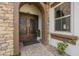 Stunning front entrance featuring a stone archway, ornate double doors, and manicured plants at 2949 E Athena Ave, Gilbert, AZ 85297