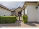 Close up of charming home with a stone archway, iron gate, and manicured hedges at 2949 E Athena Ave, Gilbert, AZ 85297