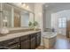 A spacious main bathroom with a granite counter, dark cabinets and soaking tub at 2949 E Athena Ave, Gilbert, AZ 85297