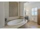 An elegant bathroom featuring a large tub, tiled wall accents, and granite countertops at 2949 E Athena Ave, Gilbert, AZ 85297
