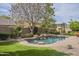 Inviting backyard featuring a refreshing pool, stone surround, and mature landscaping at 2949 E Athena Ave, Gilbert, AZ 85297