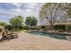 Lush backyard featuring a pool, artificial turf, and mature desert landscaping at 2949 E Athena Ave, Gilbert, AZ 85297