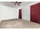 Spacious bedroom featuring neutral carpet, ceiling fan, and red curtains at 30878 W Picadilly Rd, Buckeye, AZ 85396