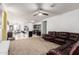 Open-concept living space with a large brown leather couch, adjoining kitchen with a breakfast bar at 30878 W Picadilly Rd, Buckeye, AZ 85396