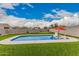 Inviting backyard pool with lounge chairs and a red umbrella, perfect for relaxation and enjoying the sunny weather at 30878 W Picadilly Rd, Buckeye, AZ 85396