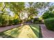 Lush backyard featuring a putting green, mature trees, and a peaceful ambiance at 3683 E Nolan Dr, Chandler, AZ 85249