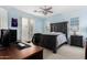 A blue bedroom with a dark wood bed frame, computer desk, and plenty of natural light at 3683 E Nolan Dr, Chandler, AZ 85249