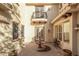 Serene courtyard with a decorative fountain, potted plants, and a wrought-iron balcony at 3683 E Nolan Dr, Chandler, AZ 85249