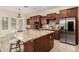 Open concept kitchen with granite countertops, stainless steel refrigerator, wooden cabinets, and a large kitchen island at 3683 E Nolan Dr, Chandler, AZ 85249