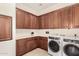 Convenient laundry room with abundant cabinets and a modern washer and dryer at 3683 E Nolan Dr, Chandler, AZ 85249