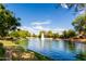 Wide shot of a tranquil pond with a fountain, embraced by lush greenery and mature trees at 3683 E Nolan Dr, Chandler, AZ 85249