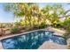 Backyard oasis featuring a refreshing pool, mature trees, and a putting green at 3683 E Nolan Dr, Chandler, AZ 85249