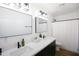 Bright bathroom featuring a double vanity with modern faucets, sleek mirrors, and a shower with a white curtain at 4025 N 8Th Ave, Phoenix, AZ 85013
