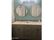 Double sink vanity with round mirrors and modern fixtures in a well-lit bathroom at 4242 N 27Th St # 2, Phoenix, AZ 85016