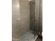 Contemporary shower features sleek gray tile, frameless glass door, and mosaic tile flooring at 4242 N 27Th St # 2, Phoenix, AZ 85016