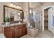 Well-lit bathroom featuring a tiled shower, vanity, and linen storage at 4249 E Nightingale Ln, Gilbert, AZ 85298