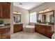 Elegant bathroom featuring dual vanities, a soaking tub, and neutral tile at 4249 E Nightingale Ln, Gilbert, AZ 85298