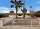 Charming single-story home featuring desert landscaping, a crisp white fence, and mature palm trees at 492 W 17Th Ave, Apache Junction, AZ 85120