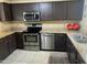 Well-lit kitchen featuring stainless steel appliances, dark cabinets, and granite countertops at 4925 E Desert Cove Ave # 236, Scottsdale, AZ 85254