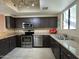 Well-lit kitchen featuring stainless steel appliances, dark cabinets, and granite countertops at 4925 E Desert Cove Ave # 236, Scottsdale, AZ 85254